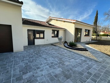 Vue sur l'aménagement extérieur avec jardinière et pierre décorative